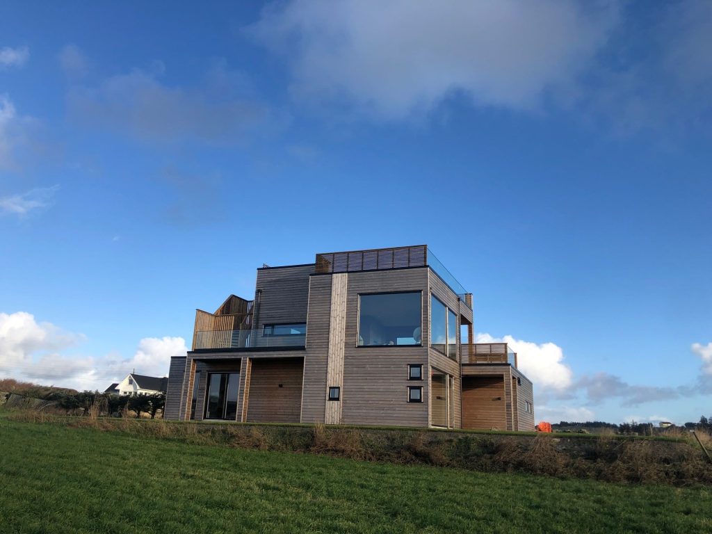 Et nybygget, moderne hus oppå en plen. 